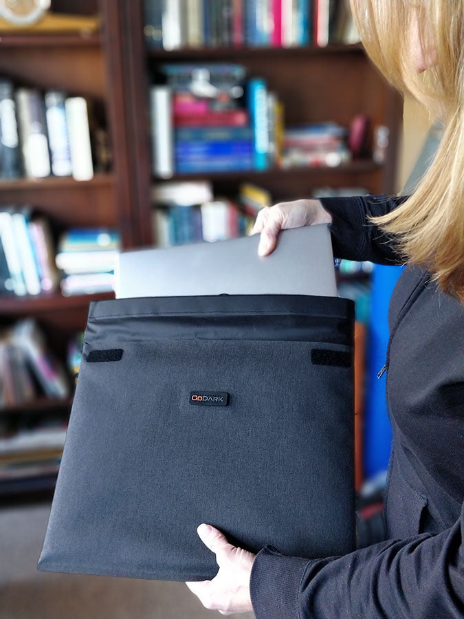 slipping a laptop inside the GoDark Faraday Sleeve 