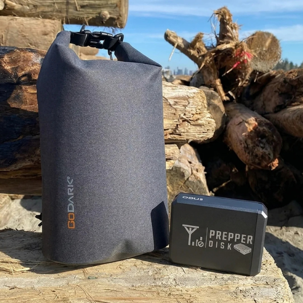 Photo of Prepper Disk and GoDark Dry Bag on a log